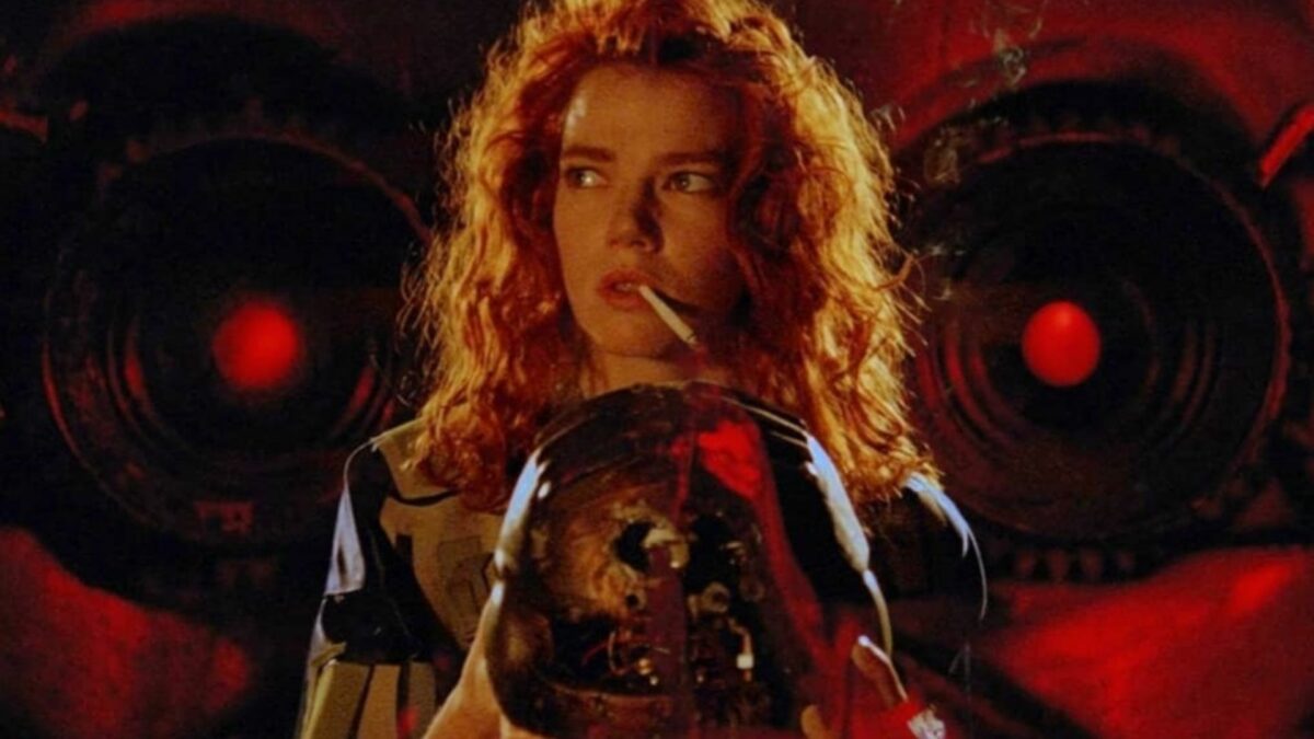 Kobieta z papierosem w ustach, trzymająca kask.