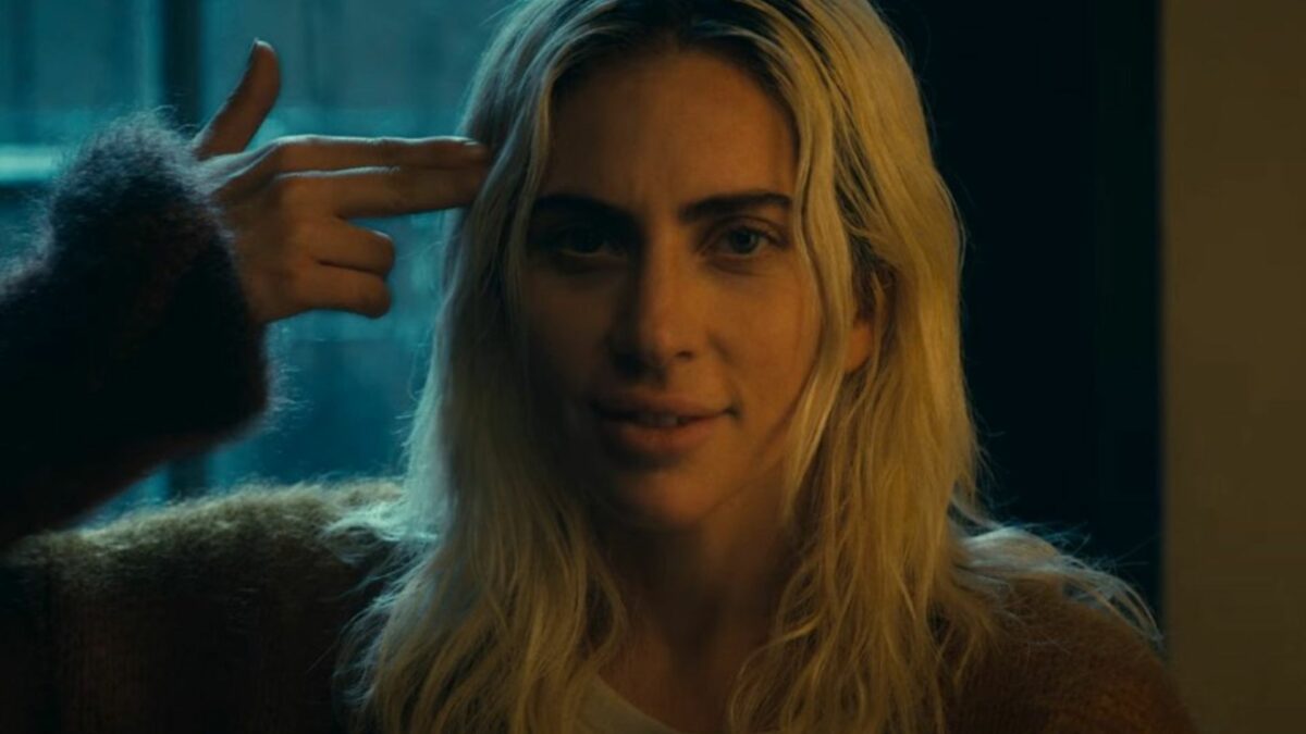 Kobieta celująca do siebie z palców ułożonych na kształt broni.