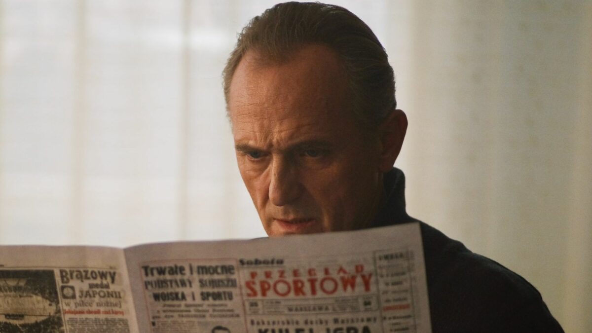 Mężczyzna czytający gazetę, jest to dodatek sportowy.