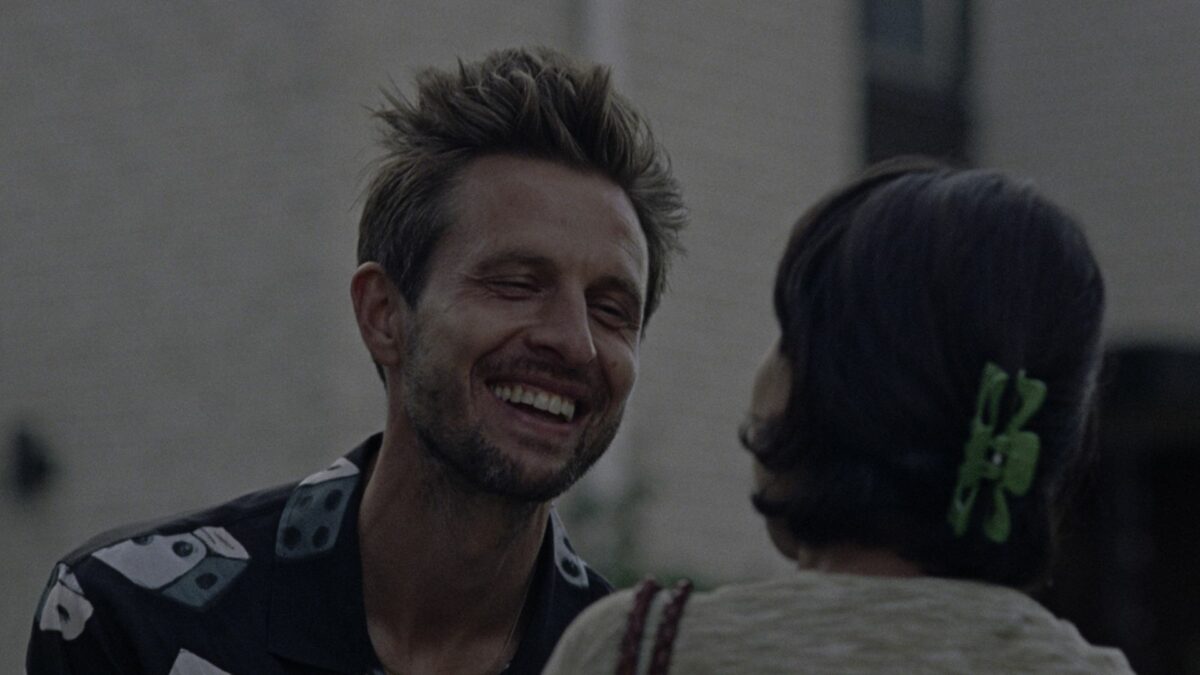 Radosny mężczyzna rozmawia z kobietą na ulicy.