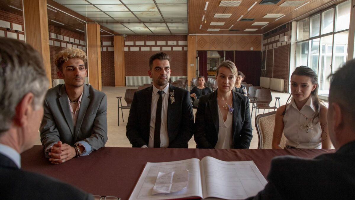 Grupa ludzi przy stole na którym znajdują się dokumenty.