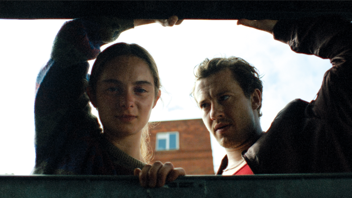 Mężczyzna patrzący na kobietę. Kobieta patrzy w dal.