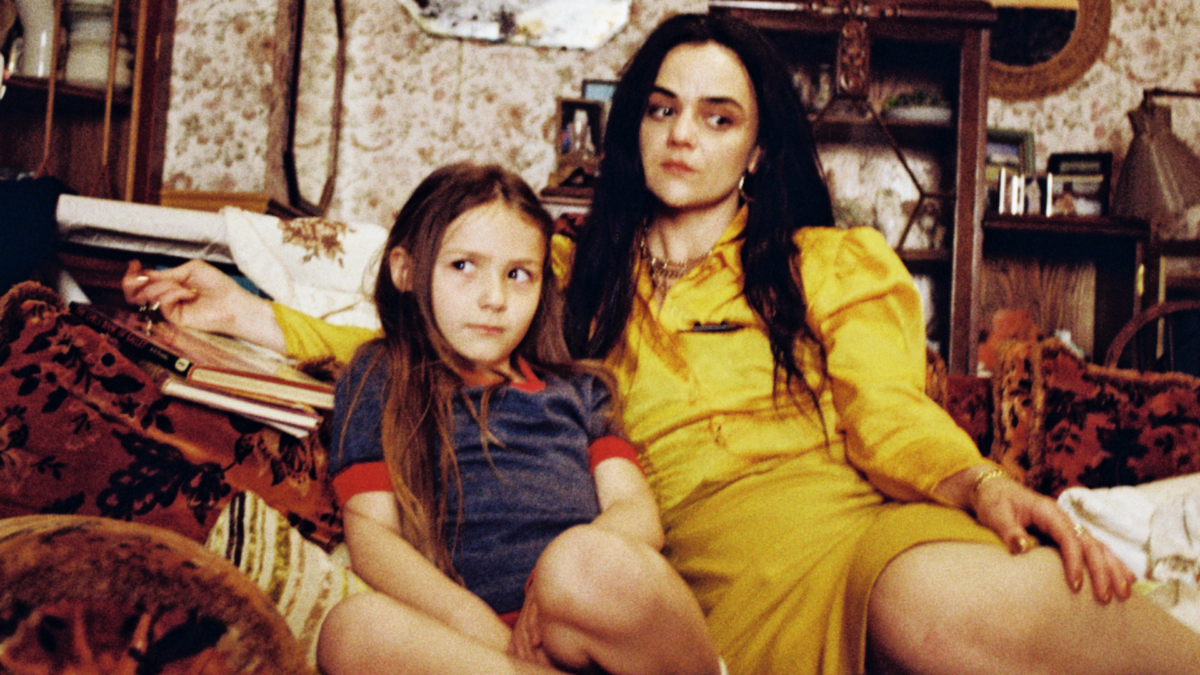 Kobieta siedząca z dziewczynką na kanapie.