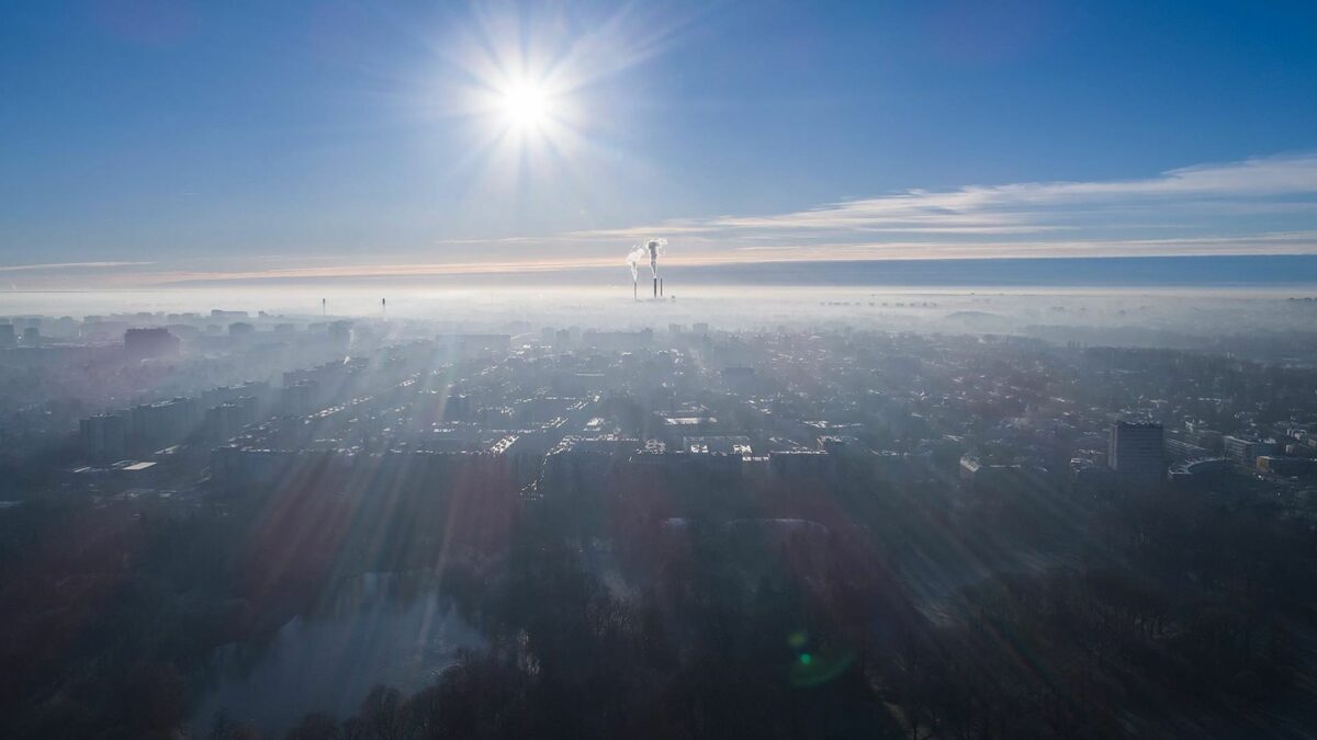 Krajobraz na którym widać w oddali kopcące kominy.