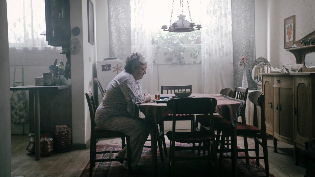 Samotna kobieta siedzi przy stole w kuchni.