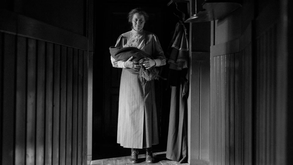 Kadr z położną trzymającą dziecko.