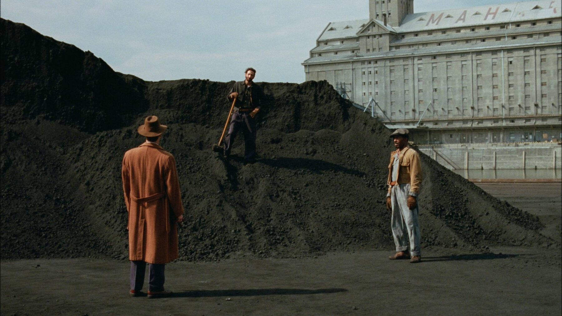 Dwójka mężczyzn spotyka się na składowisku węgla.