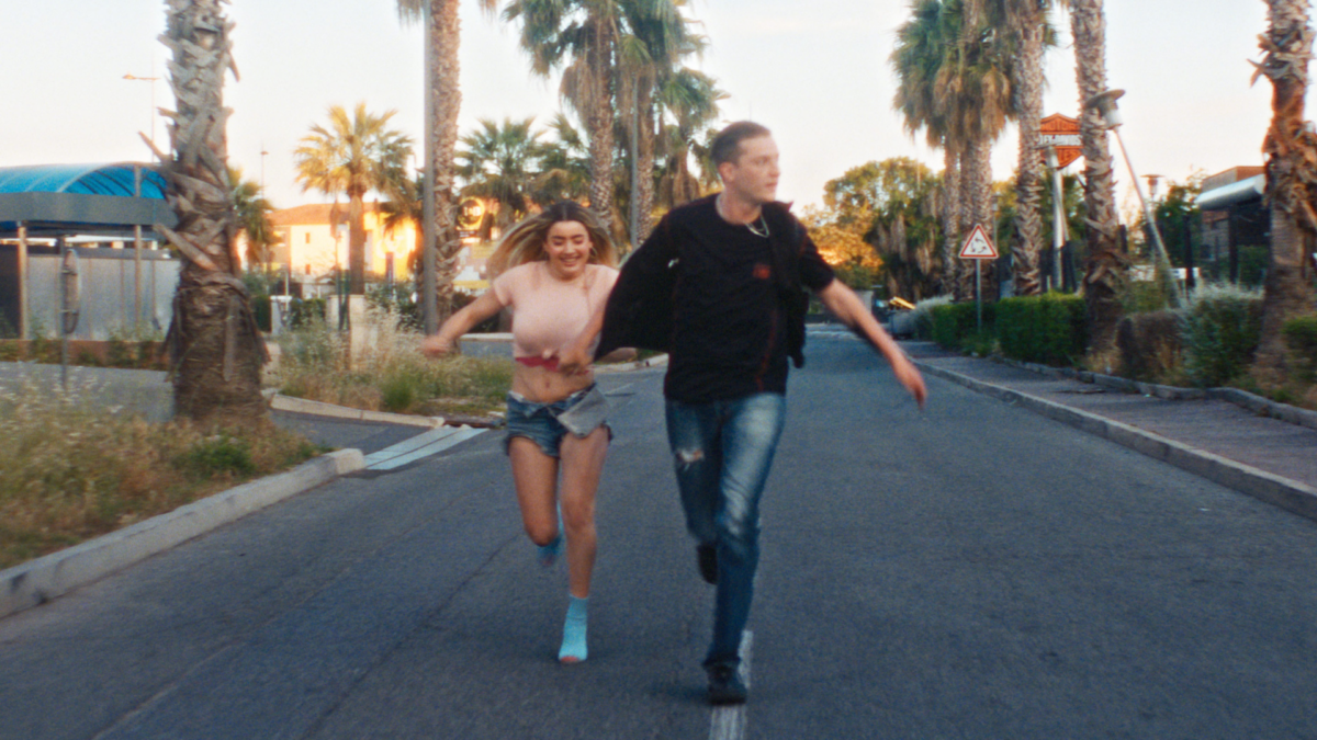 Młoda dziewczyna biegnie ulicą za chłopakiem.