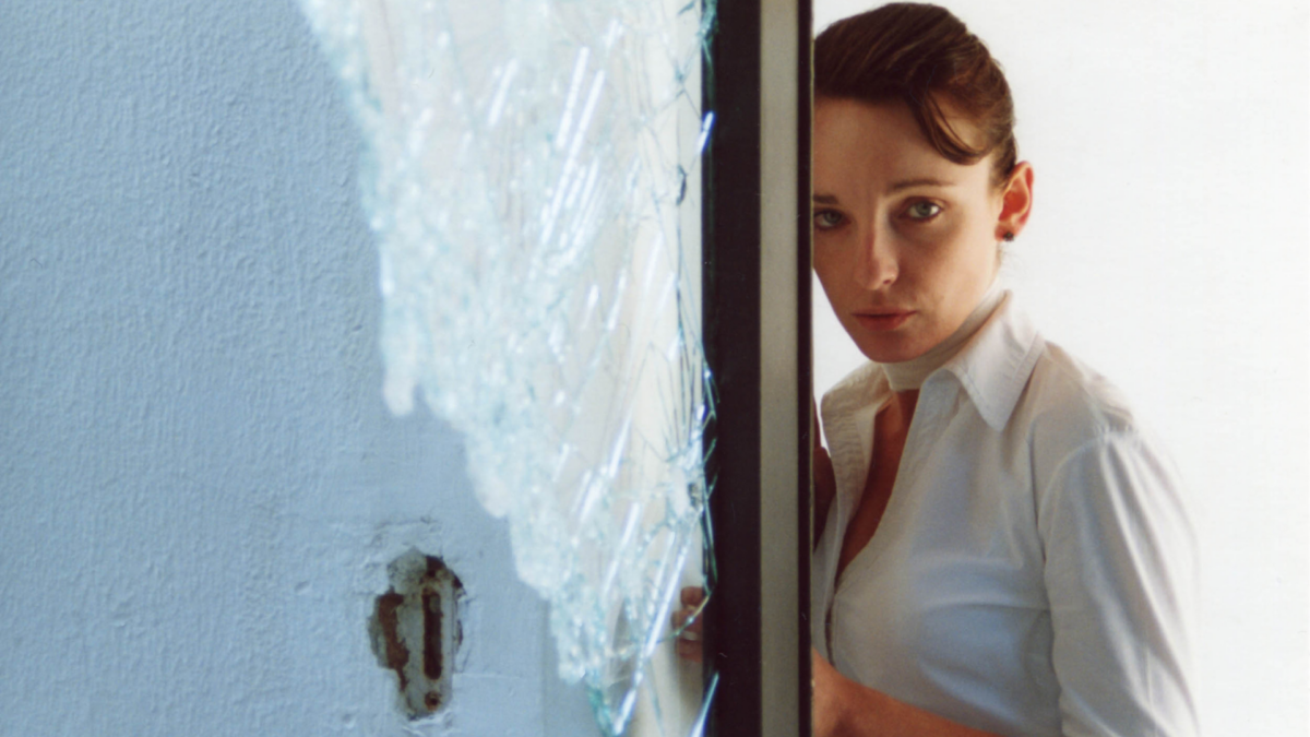 Kobieta stojąca przy białej ścianie.