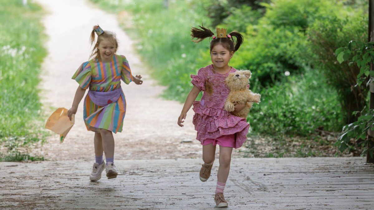 Kadr z filmu dla dzieci, dwie dziewczynki bawią się na dworze.