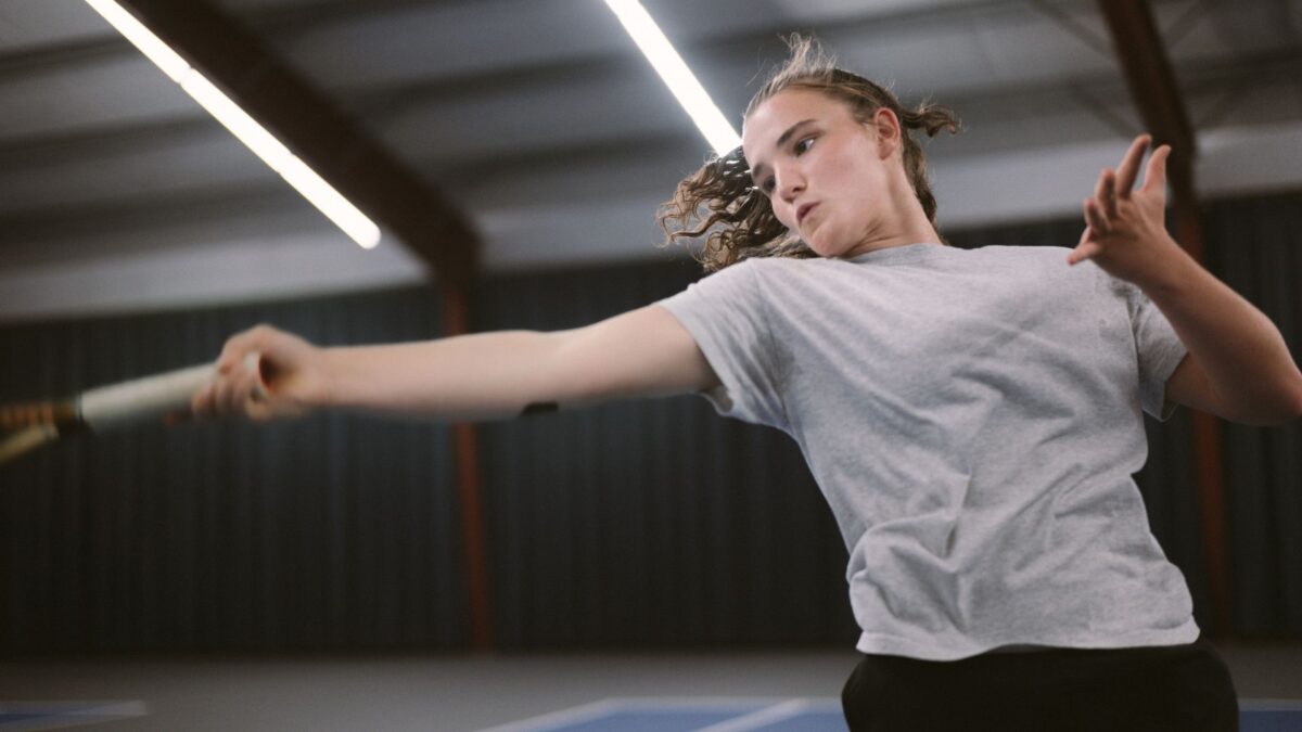 Młoda dziewczyna podczas treningu w sali tenisowej.