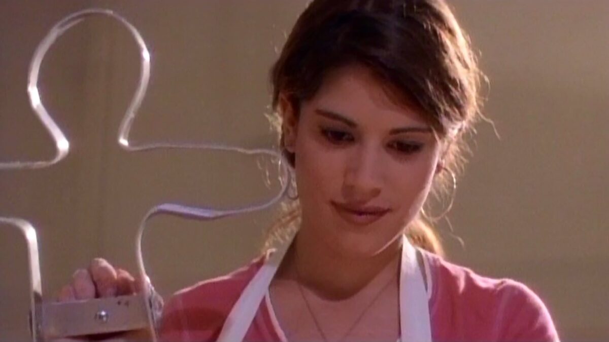 Kobieta w fartuch z foremką na ciastkowe ludziki piecze w kuchnii.