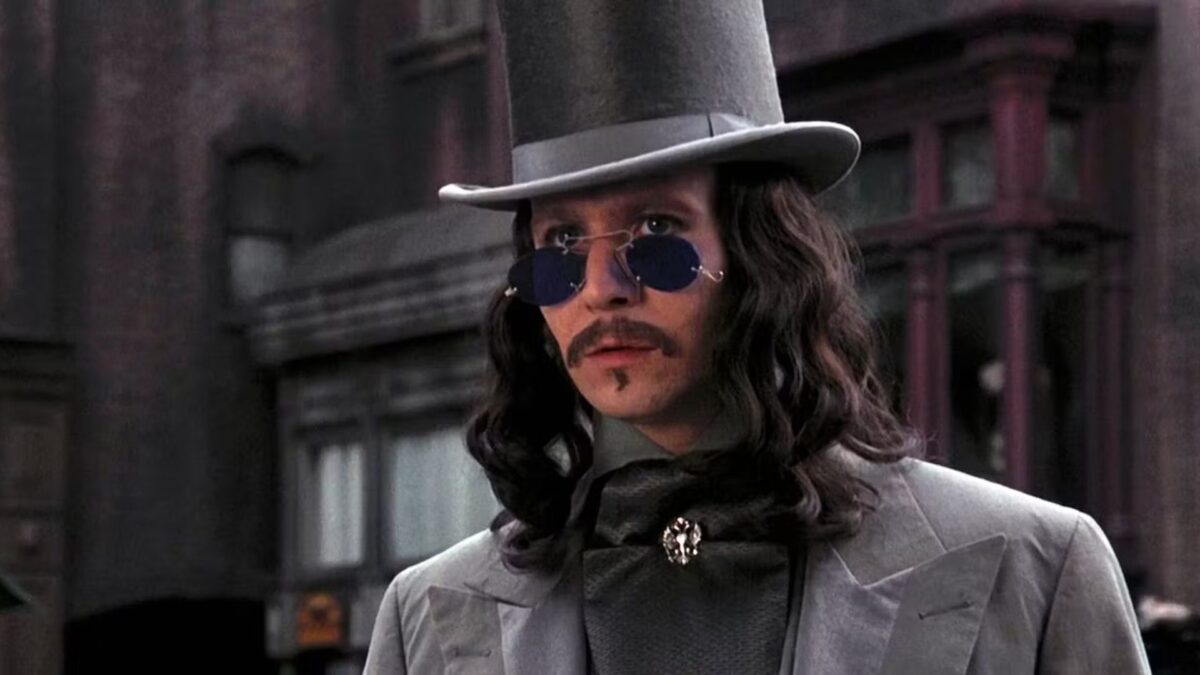 Tajemniczy mężczyzna w kapeluszu i ciemnych okularach na ulicy.