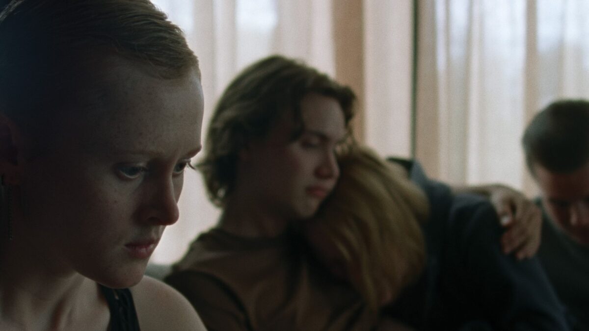 Grupa młodych ludzi pociesza swoją koleżankę.