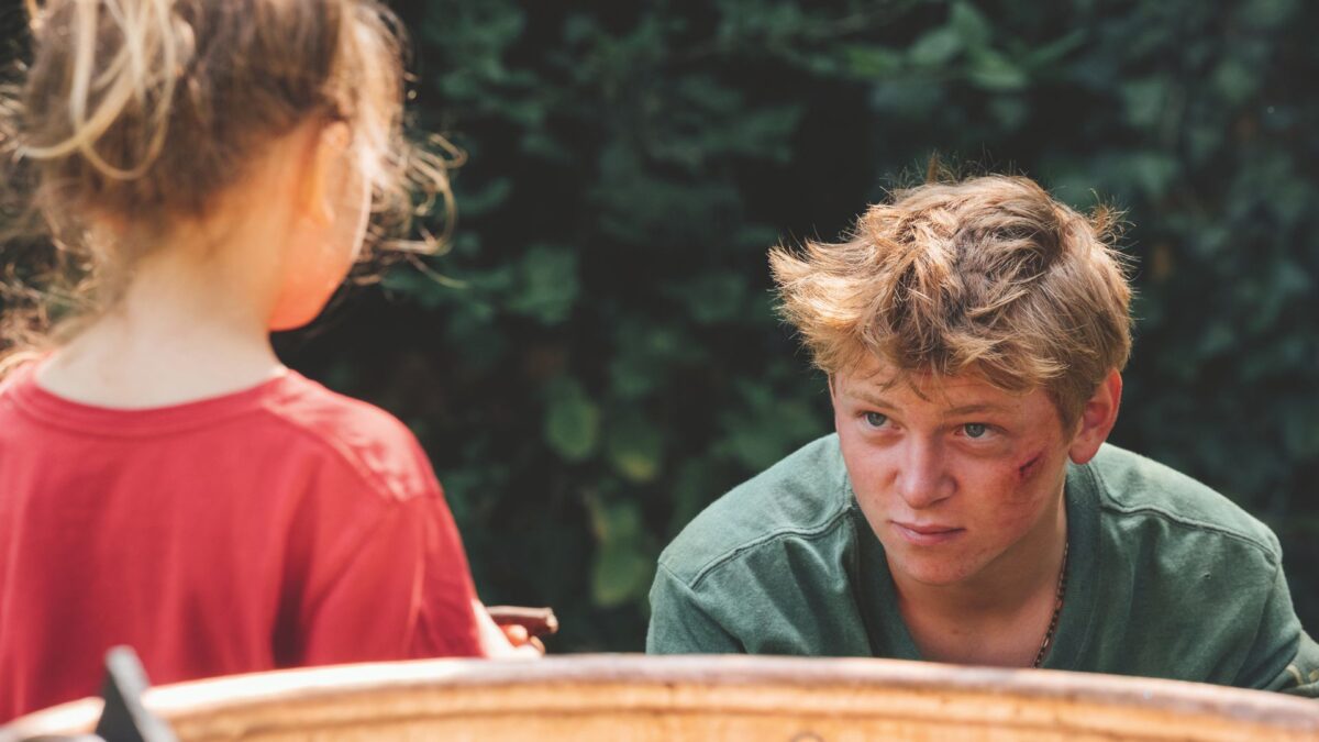 Chłopak przy pracy przy ciągniku rozmawia z młodą dziewczyną.