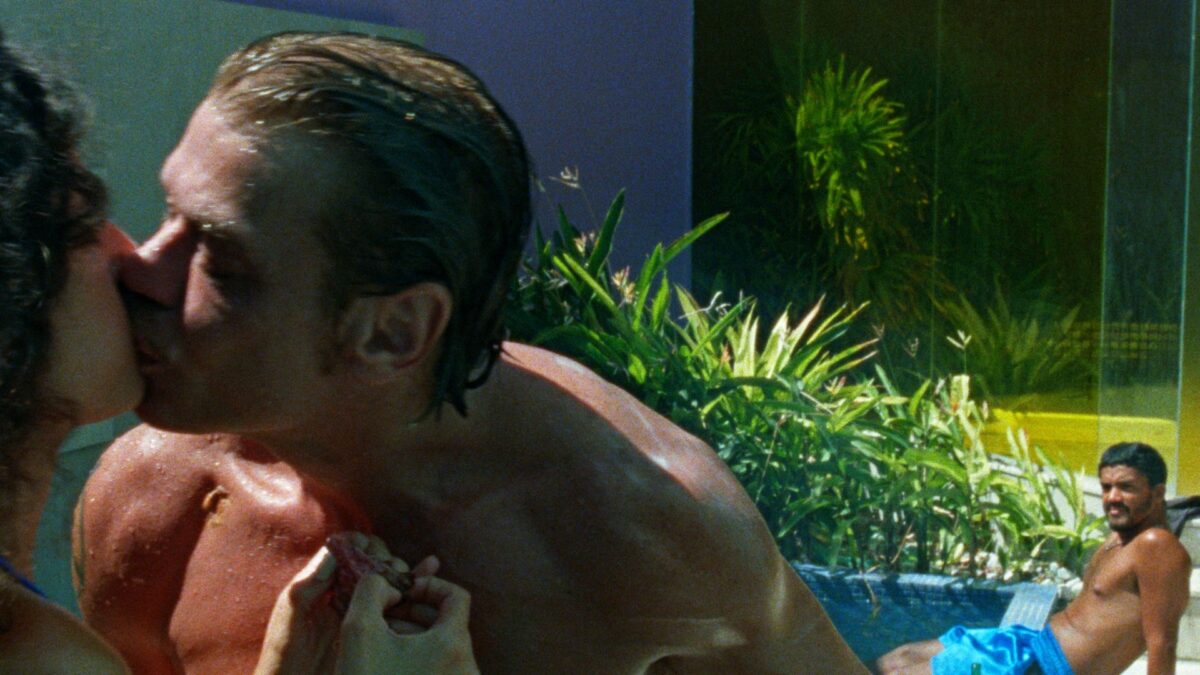 Kadr z basenu, mężczyzna przygląda się całującej parze.