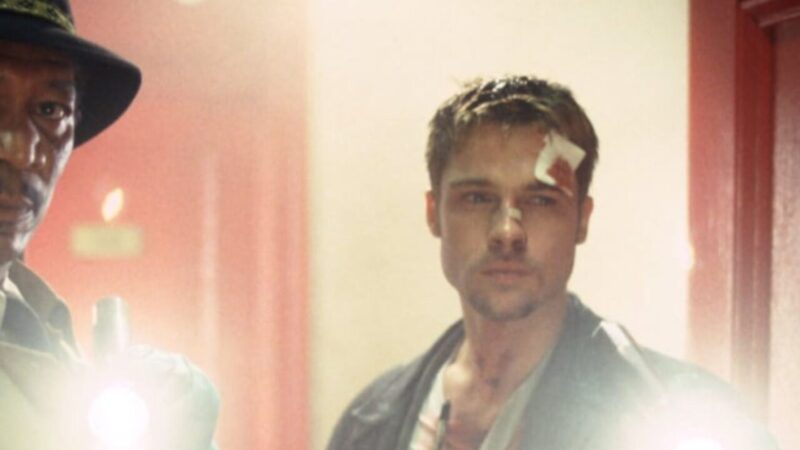 Zraniony mężczyzna idzie za plecami policjanta.