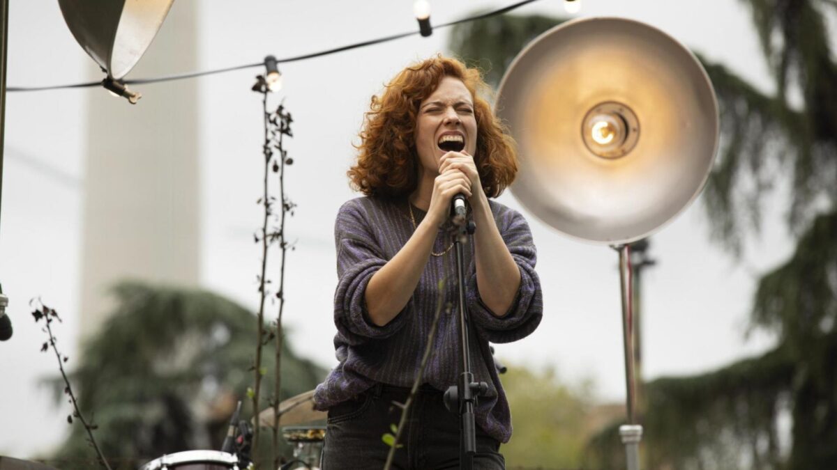 Kobieta śpiewająca na scenie.