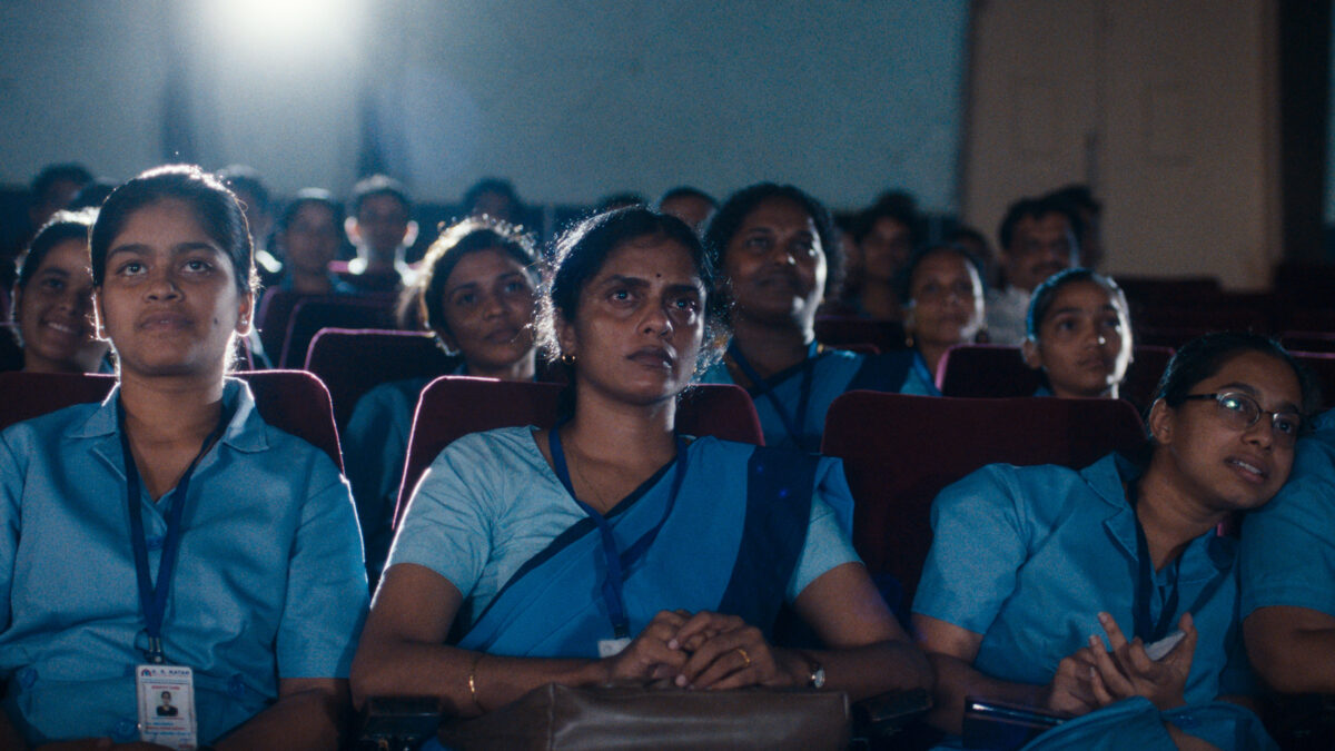 Zbliżenie na kobiety w ciemnej sali kinowej.