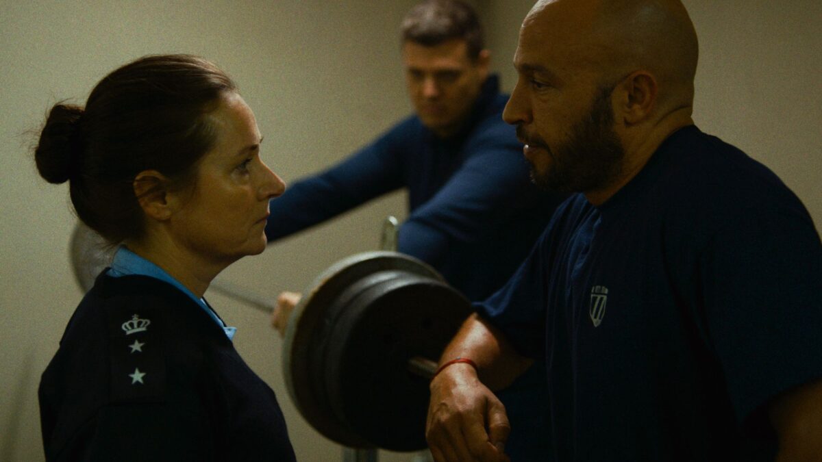 Kadr z policyjnej siłowni, funkcjonariuszka rozmawia z kolegą z pracy.