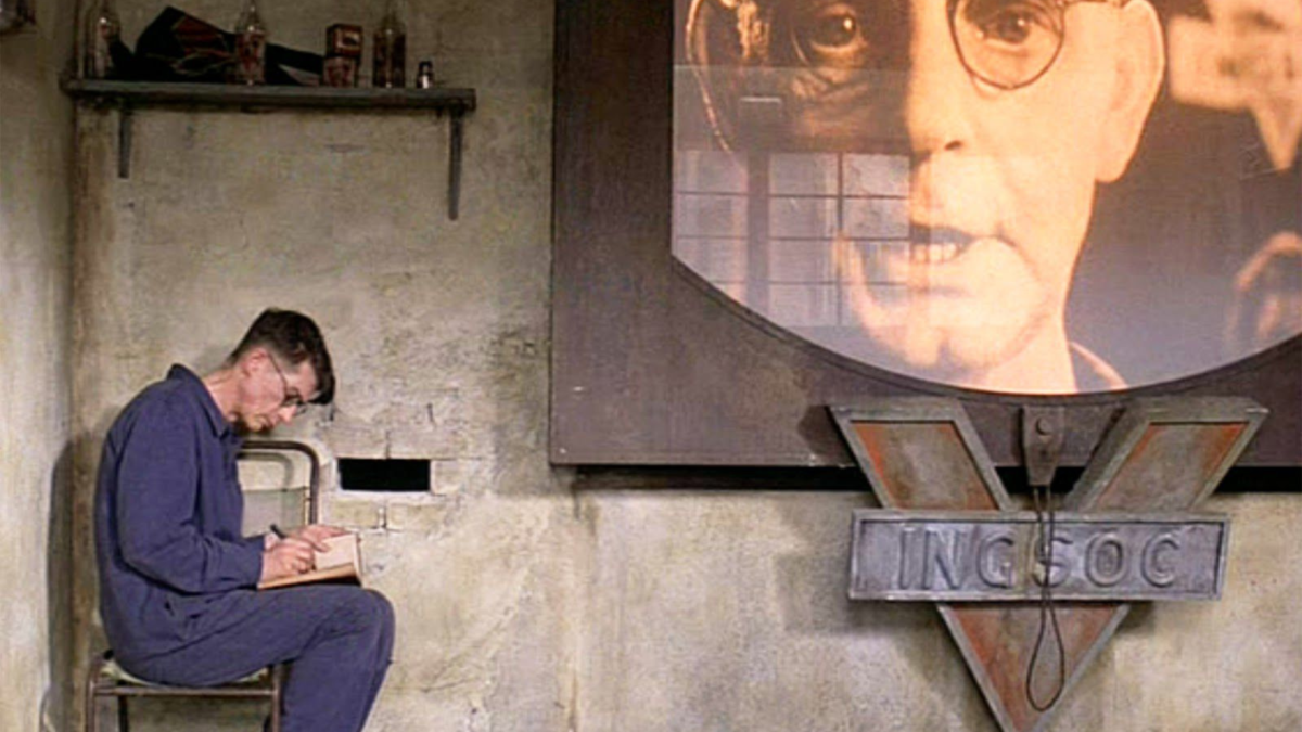 Mężczyzna siedzący na krzesełku i robi notatki w zeszycie.