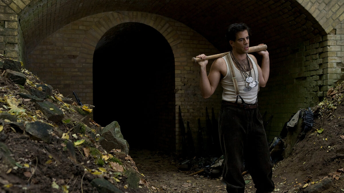 Mężczyzna z kijem bejsbolowym w bunkrze.