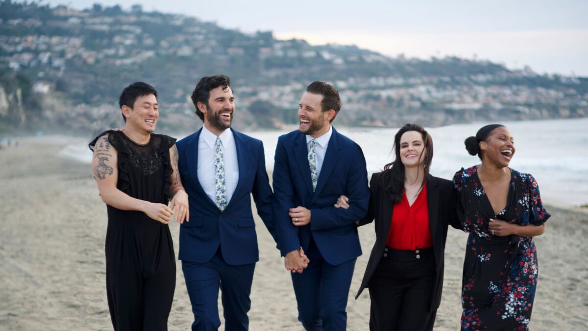 Młodzi ludzie na plaży w eleganckich strojach.