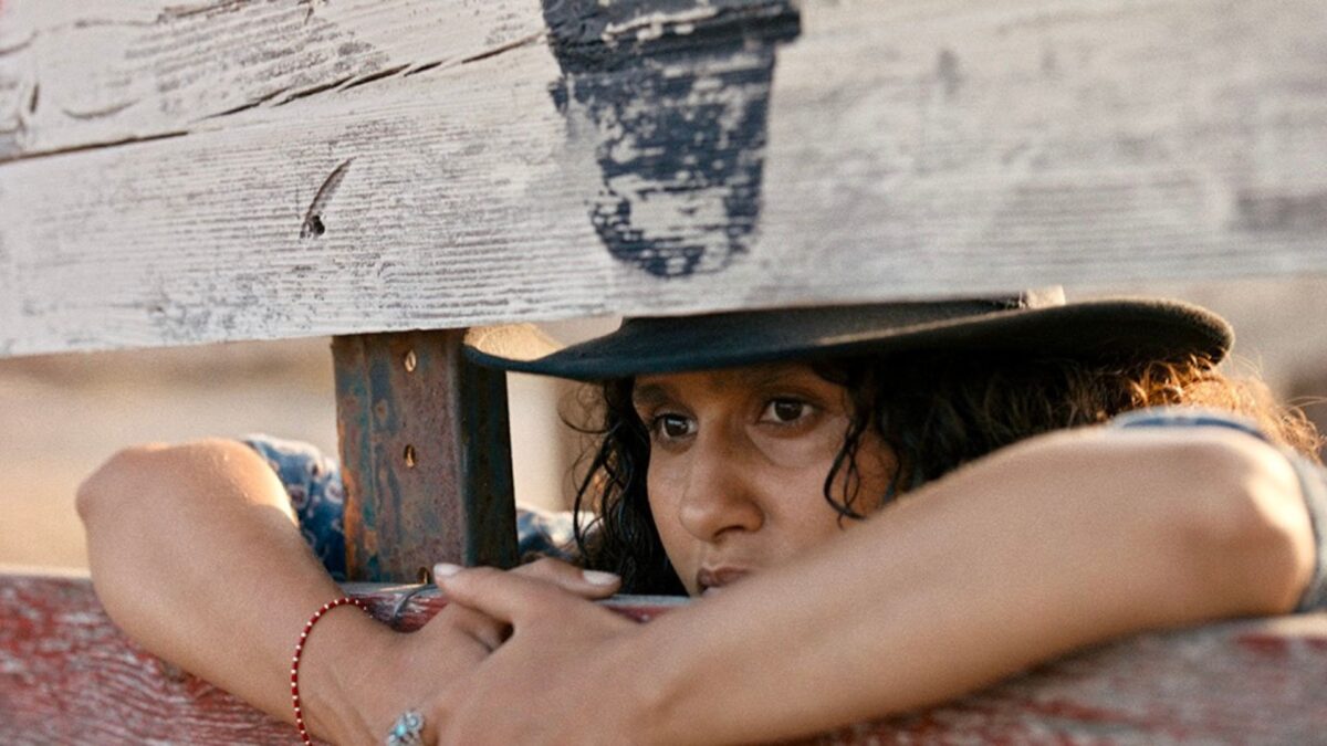 Kobieta wygląda przez ogrodzenie.