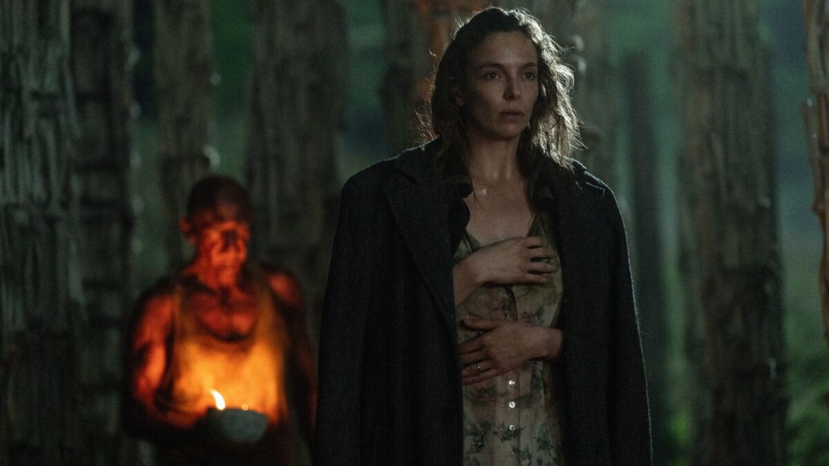 Zbliżenie na kobietę przebywającą w nocy w lesie.